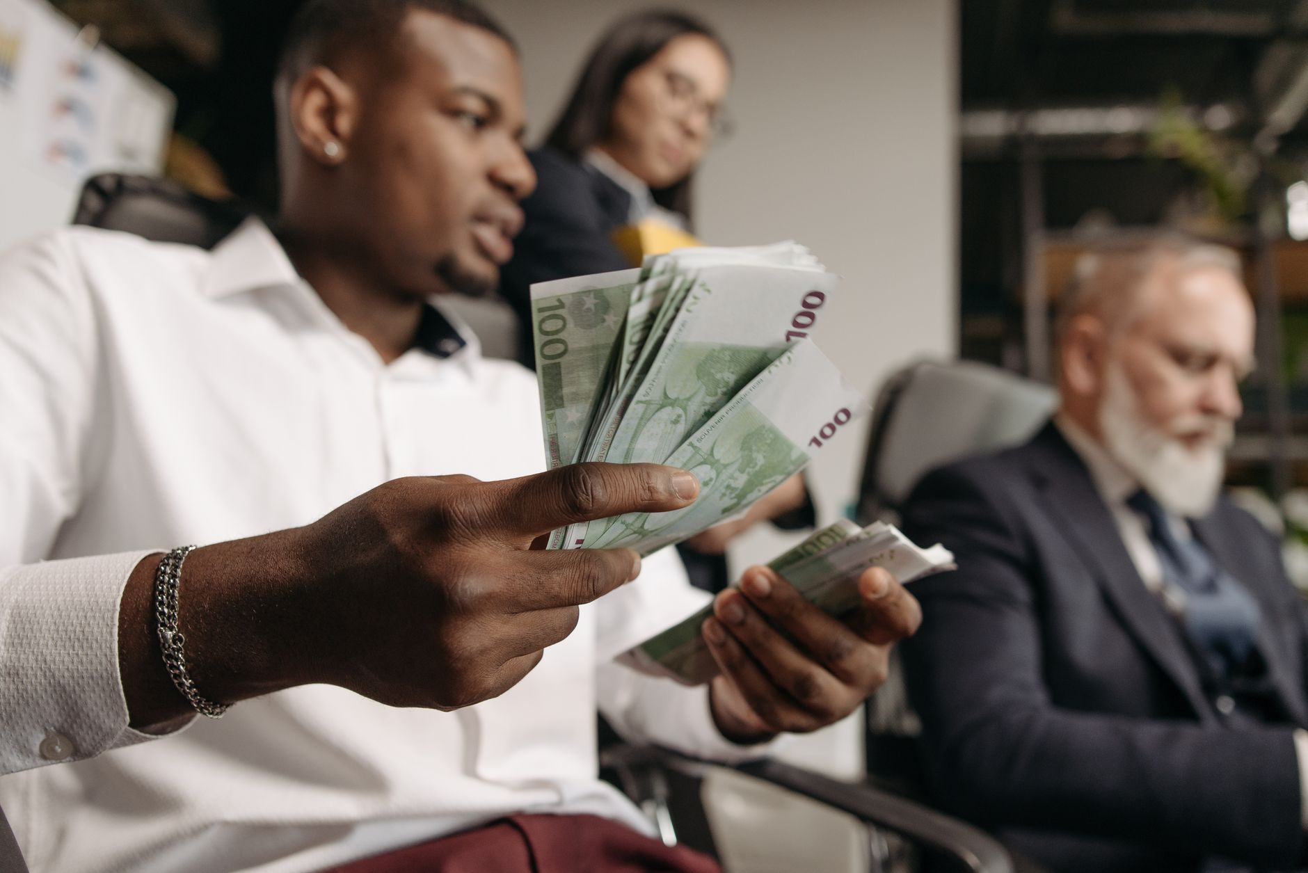 pexels-photo-7654624 man in white long sleeve shirt holding a banknotes